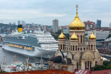 Vladivostok, Primorsky Krai, Rusya, 09.06.2019, Doğu ekonomik forumu sırasında yolcu gemisi Costa Serena bayrakların arka planda iskelede duruyor, Katedral ve Haliç Körfezi