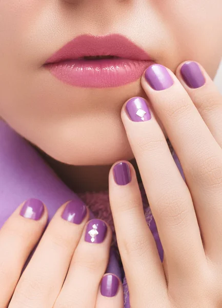 Фиолетовый рисунок ногтей и женское лицо крупным планом — стоковое фото