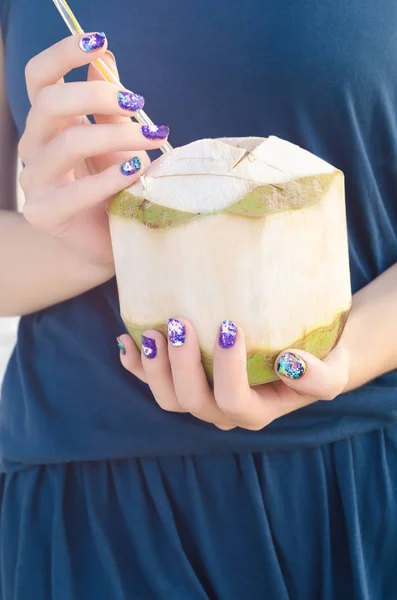 Женская рука с фиолетовыми наклейками для ногтей с кокосом — стоковое фото