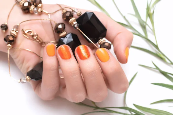 Kobieta ręka z pomarańczowym paznokci na białym tle — Zdjęcie stockowe