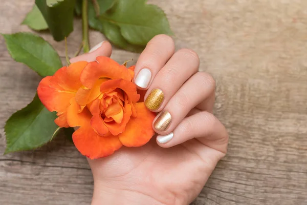 Kobieta ręka ze złotym paznokci projekt gospodarstwa Róża Kwiat — Zdjęcie stockowe