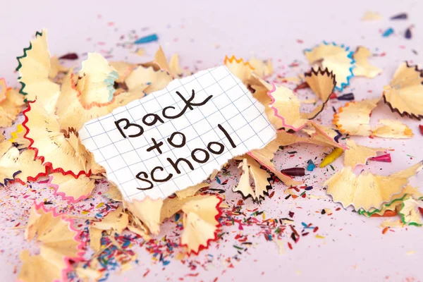 Back to school inscription on paper on pink background. — Stock Photo, Image