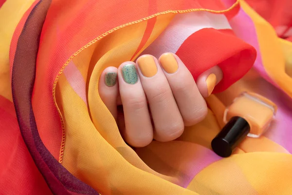 Женская рука с желтым и зеленым дизайном ногтей . — стоковое фото