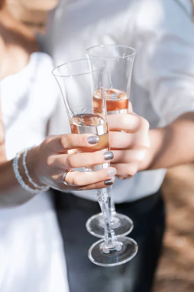 Las copas de boda con el champán en las manos de pareja . —  Fotos de Stock