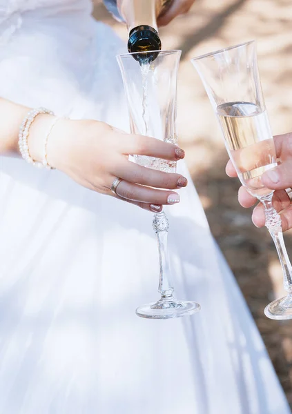 Wedding glasses with champagne in couple's hands. — Stock Photo, Image