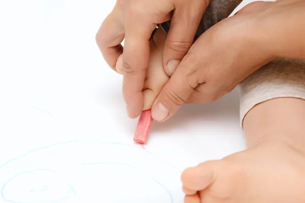 Τα χέρια του παιδιού είναι βαμμένα με χρωματιστά μολύβια σε ένα λευκό φύλλο χαρτί. — Φωτογραφία Αρχείου