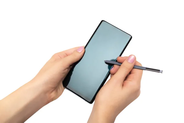 Kvinnliga händer med mobiltelefon med penna på vit bakgrund Stockfoto