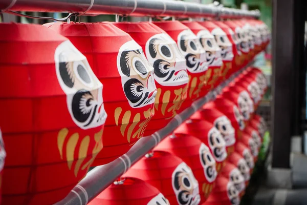 Muñecas Daruma Las muñecas simbólicas de la suerte japonesa colgando en la fila con la fortuna de traducción de texto . —  Fotos de Stock