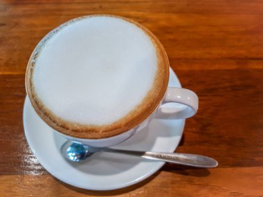 Ahşap masa üzerinde beyaz fincan Üst Cappuccino