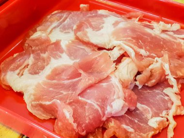 Kırmızı tabakta çiğ domuz göbeği