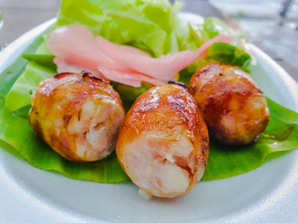 Yeşil muz yaprağı üzerinde Tay sosis