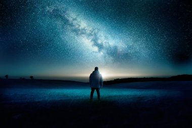 Adam sahanın ay ve Samanyolu gece gökyüzü doldurmak şaşkınlık ve hayretle izliyor. Gece saat manzarası. Fotoğraf kompozit.