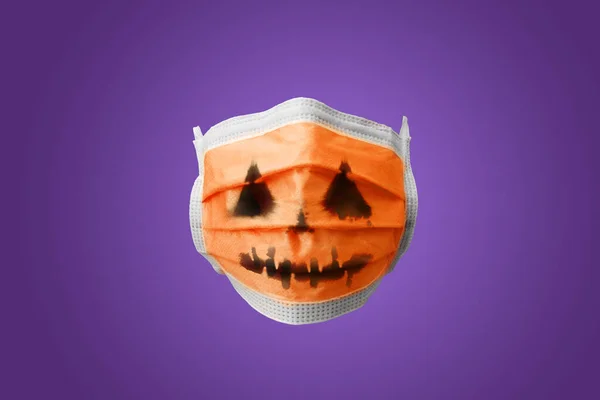 A decorated face mask with a jack O lantern pumpkin face.