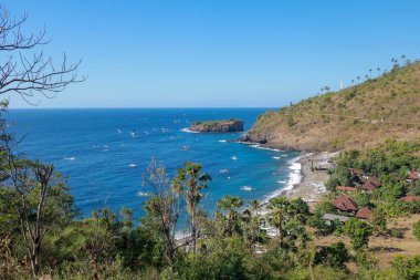 BALI, INDONEZYA - 29 Temmuz 2019: Geleneksel yelkenli jukung kanosundaki bir balıkçı yakalayışıyla Endonezya, Bali 'deki Japon Enkaz plajına dönüyor.
