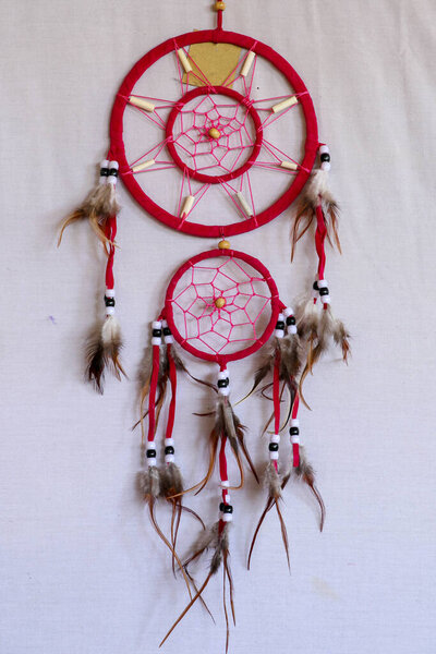 Pink ash crochet doily dream catcher close up on dark gray textured background. Texture of concrete, copy space for text. White background.