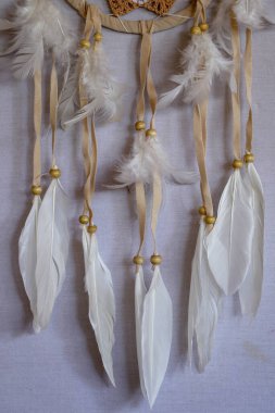 Beyaz rüya yakalayıcısına yaklaş. Tüyler ve boncuklarla süslenmiş küçük beyaz bir halka..