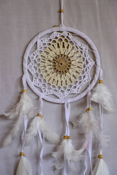 White crocheted dreamcatcher, an Indian amulet that protects the sleeper from evil spirits and diseases. Soft focus. Closeup.