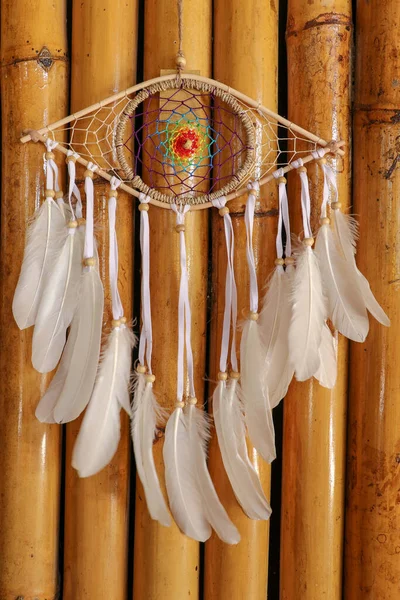 god eye of providence dreamcatcher with white feathers on a wodden background.