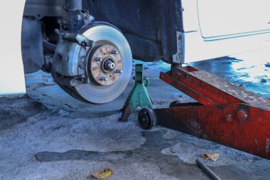 Yeni lastik değiştirme işlemi sırasında arabanın ön disk freni. Ön pervane ve kalibresini gösteren kenar sökülmüş..