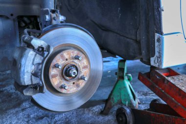 Yeni lastik değiştirme işlemi sırasında arabanın ön disk freni. Ön pervane ve kalibresini gösteren kenar sökülmüş..