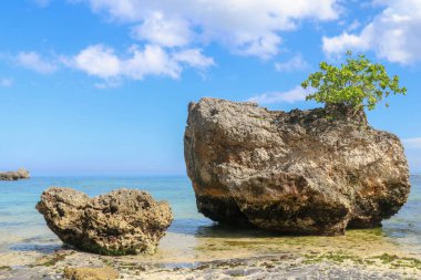 Endonezya, Bali 'deki Padang Padang plajının güzel bir manzarası. Dev kayalar ve kaya oluşumları Hint Okyanusu 'nun üzerinde birleşiyor..
