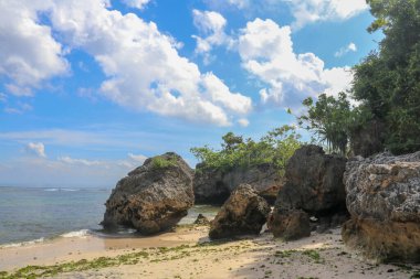 Endonezya, Bali 'deki Padang Padang plajının güzel bir manzarası. Dev kayalar ve kaya oluşumları Hint Okyanusu 'nun üzerinde birleşiyor..