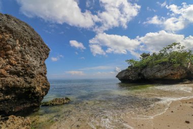 Bali Endonezya 'daki Padang Padang Plajı. Doğal tatil geçmişi. Dev kayalar ve kaya oluşumları Hint Okyanusu 'nun üzerinde birleşiyor..