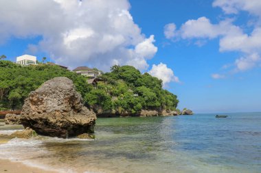 Endonezya, Bali 'deki Padang Padang plajının güzel bir manzarası. Dev kayalar ve kaya oluşumları Hint Okyanusu 'nun üzerinde birleşiyor..