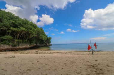 Okyanus kıyısındaki kırmızı bayraklar burada yüzme tehlikesine karşı uyarıyorlar. Dalgalar yüzücülerden çok sörfçüler içindir..