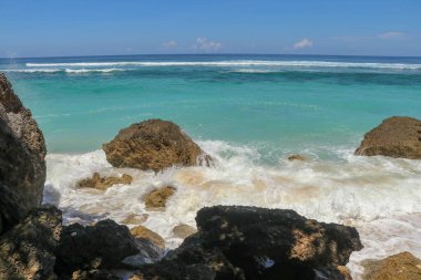 Kıyıya dalgalar sıçrıyor. Dalgalar deniz kıyısına vuruyor.