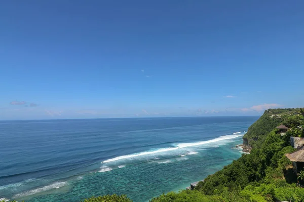 大海上美丽的蓝色落日 波涛汹涌 悬崖峭壁丛生 巴厘岛具有热带和异国情调的性质 太阳升起在大海和海洋之上 日落时的幻影 — 图库照片