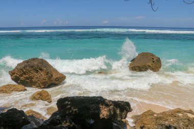 Kıyıya dalgalar sıçrıyor. Dalgalar deniz kıyısına vuruyor.