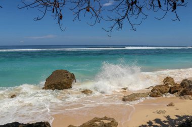 Kıyıya dalgalar sıçrıyor. Dalgalar deniz kıyısına vuruyor.