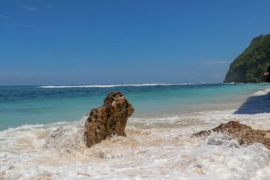 Kıyıya dalgalar sıçrıyor. Dalgalar deniz kıyısına vuruyor.