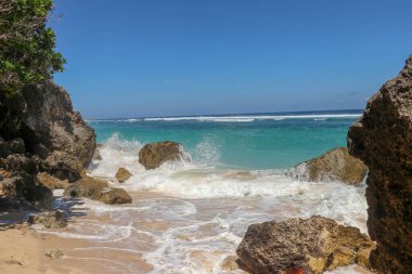 Kıyıya dalgalar sıçrıyor. Dalgalar deniz kıyısına vuruyor.