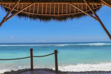 Sahildeki açık hava restoranı. Kumsaldaki kafe, okyanus ve gökyüzü. Endonezya, Bali 'deki bardan sahile bak. Cennet kumsalında dinleniyorlar..