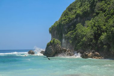 Güneşli bir günde, beyaz kumlu ve hareketsiz turkuaz okyanuslu güzel kumlu bir sahil. Mavi gökyüzündeki beyaz bulutlar suya yansıyor. Maldivler, mükemmel hava manzarası.