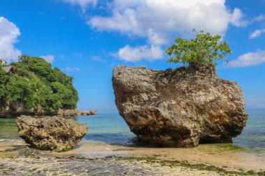 Endonezya, Bali 'deki Padang Padang plajının güzel bir manzarası. Dev kayalar ve kaya oluşumları Hint Okyanusu 'nun üzerinde birleşiyor..
