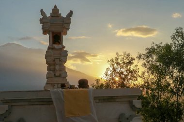Hindu sunağı Endonezya 'da Bali' de bulunuyor. Dramatik gün batımı ışığı, arka planda güzel bir dağ. Hindu sunağı günbatımında çekildi. Beyaz taştan yapılmış kurban sunağı..