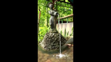 Bahçesinde antik Hindu heykeli olan Çeşme, Bali Endonezya