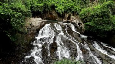 Asya 'daki Endonezya' nın Bali adasında insansız hava aracı ile çekilmiş. Ormanın ortasında güzel bir şelalenin üzerinde uçmak. Benekli ve tropikal doğa kavramı