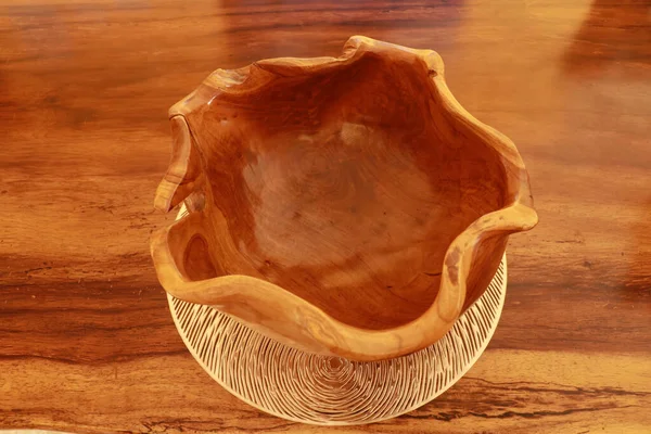 Empty clay bowls on a wooden table. Top view. Close up of a carved wooden bowl. Decorative wooden bowl, artwork.
