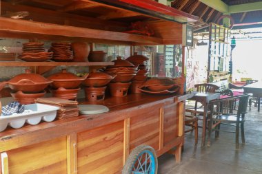 Koyu arkaplanda baharat ve malzemeler olan kil çömlek. Asya yemekleri, sağlıklı ya da yemek pişirme konsepti. İçinde büyük çömlekler olan ahşap bir araba..