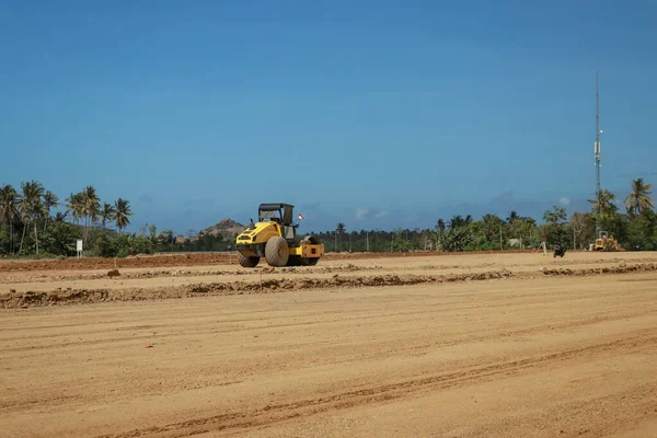 Working machines and heavy equipment adjust the terrain of the race track. Construction of the area and the Moto GP Mandalika racing circuit, West Nusa Tenggara, Lombok, Indonesia. Building a racetrack for motorcycles.
