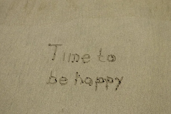 Close-up van de tijd om gelukkig tekst en glimlach Geschreven op zand op het strand — Stockfoto