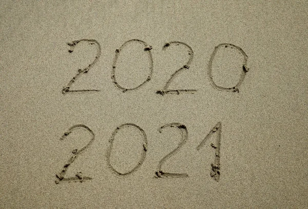 Happy New Year 2021 text on the sea beach. Abstract background photo of coming New Year 2021 and leaving year of 2020