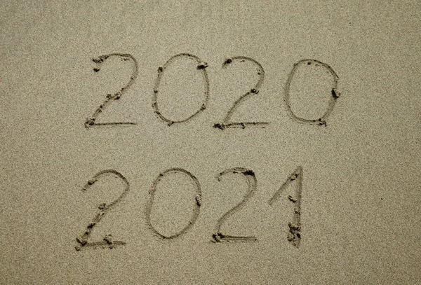 Happy New Year 2021 text on the sea beach. Abstract background photo of coming New Year 2021 and leaving year of 2020