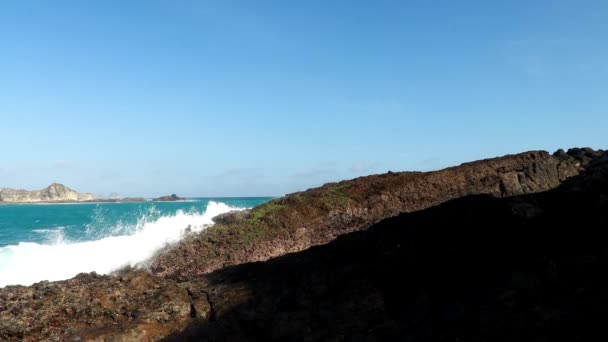 Onde blu dell'Oceano Pacifico che colpiscono rocce vulcaniche della costa a Tanjung Aan, Lombok, Indonesia — Video Stock