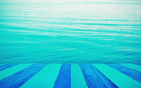 Mesa de madera vacía con fondo azul de agua de mar. bueno para pro —  Fotos de Stock