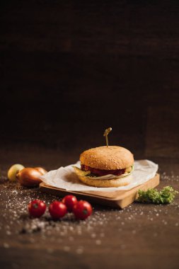 Lezzetli ve sulu burger masada yatıyor..